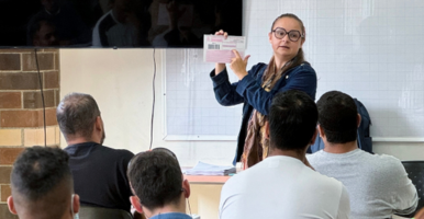 Fotografía de docente dando una indicación en un salón de clase.