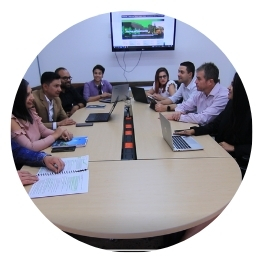 Grupo de personas en una sala de juntas, participando en una reunión.