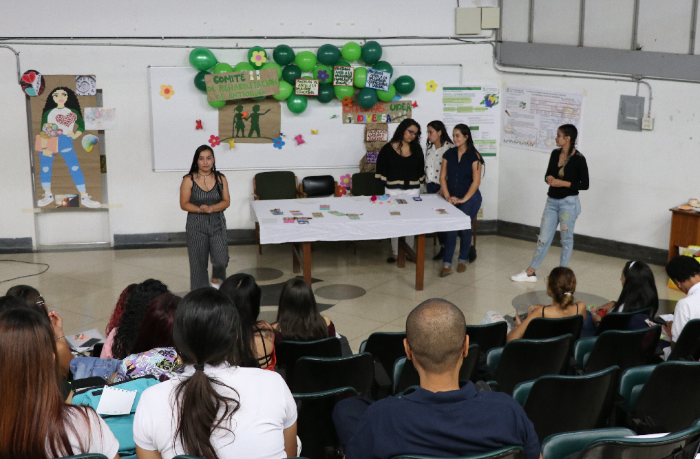 Tres íconos de siluetas de personas y una mano señalando al ícono de la mitad.