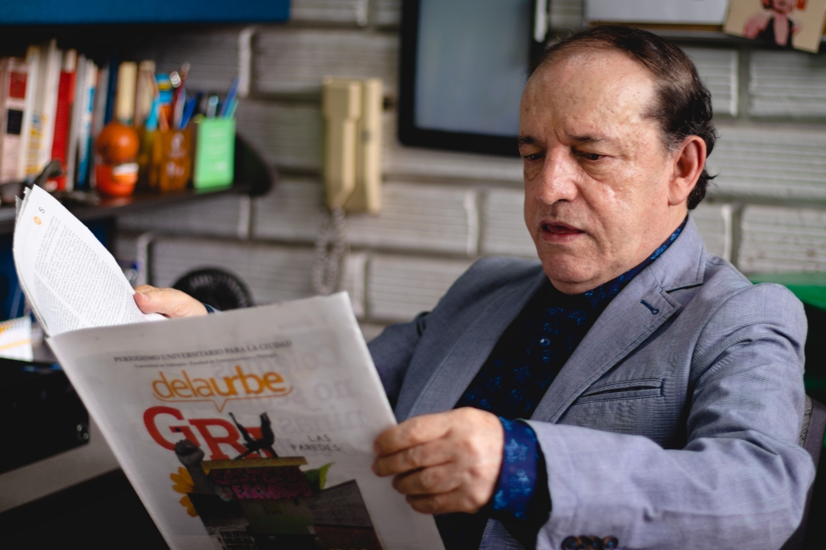 Profesor Gonzalo medina lee un ejemplar del periódico De la Urbe.